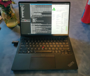 Sway window manager running two terminals on the left and firefox on the right. Firefox shows the wiki page for the Thinkpad X13s, the laptop in the photo. Terminals show pmbootstrap output and some misc. notes.