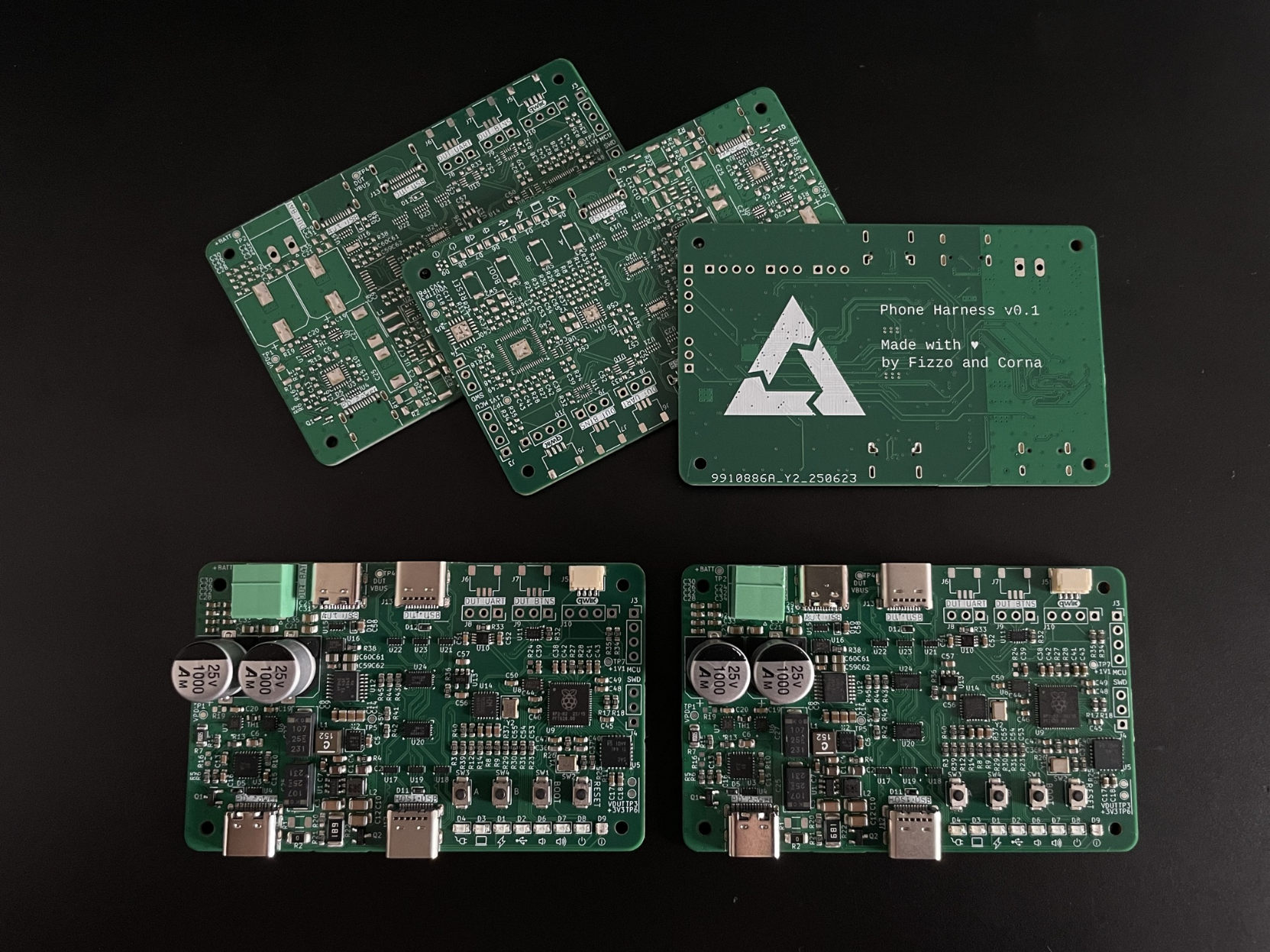 Five green PCBs laying near or on top of each other. One is flipped over, showing the postmarketOS logo and some data on the PCB.