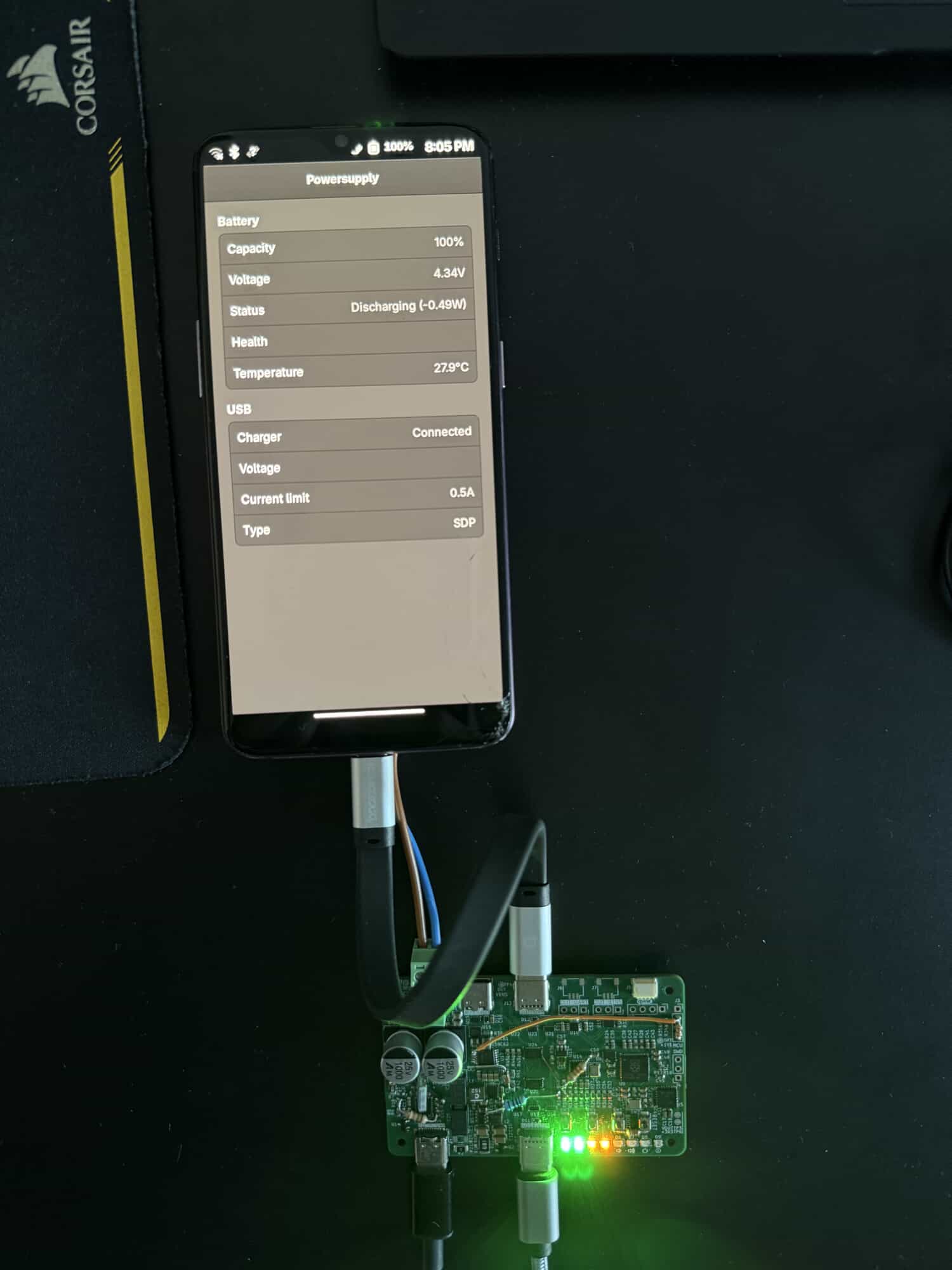 A photo of hand-patched v0.1 PCB powering a OnePlus 6T. The phone is running powersupply on phosh
